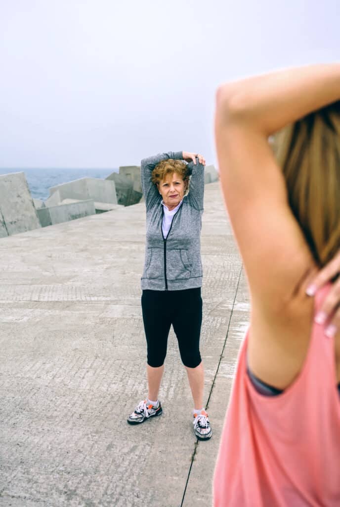 woman stretching with senior woman